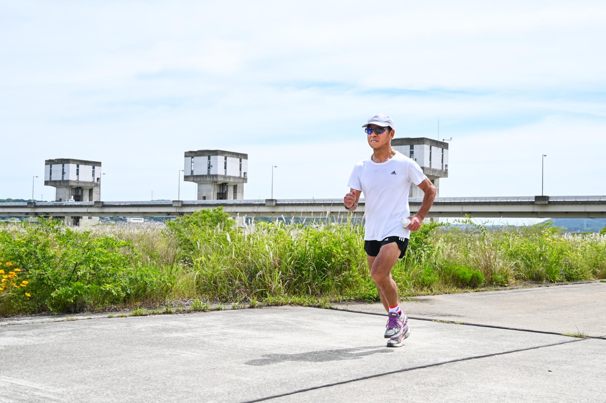河川敷でランニングをする男性