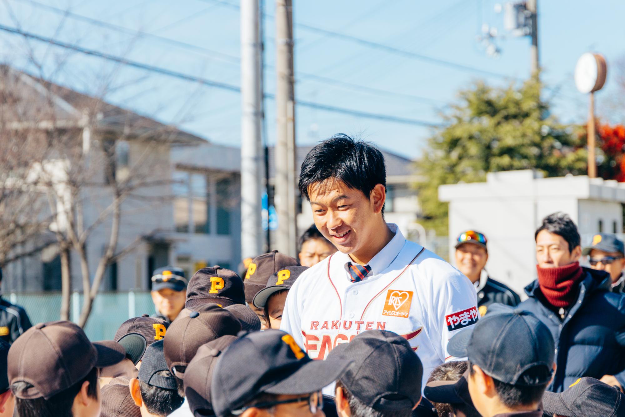 野球チームの子どもたちに囲まれる坂井さん