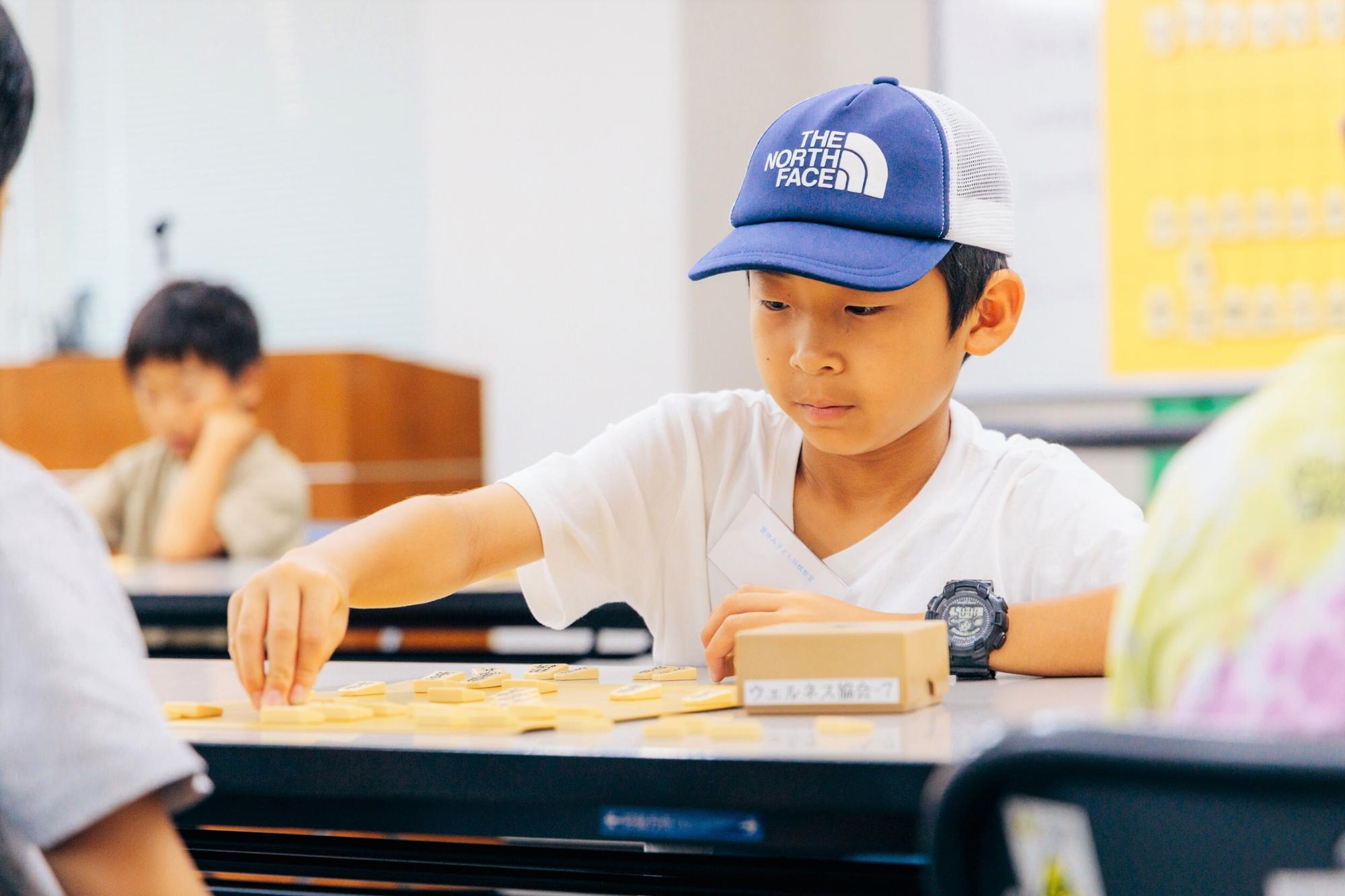 将棋教室で将棋を指す男の子