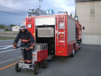 電動ホースカーに消防隊員が乗車した様子の写真