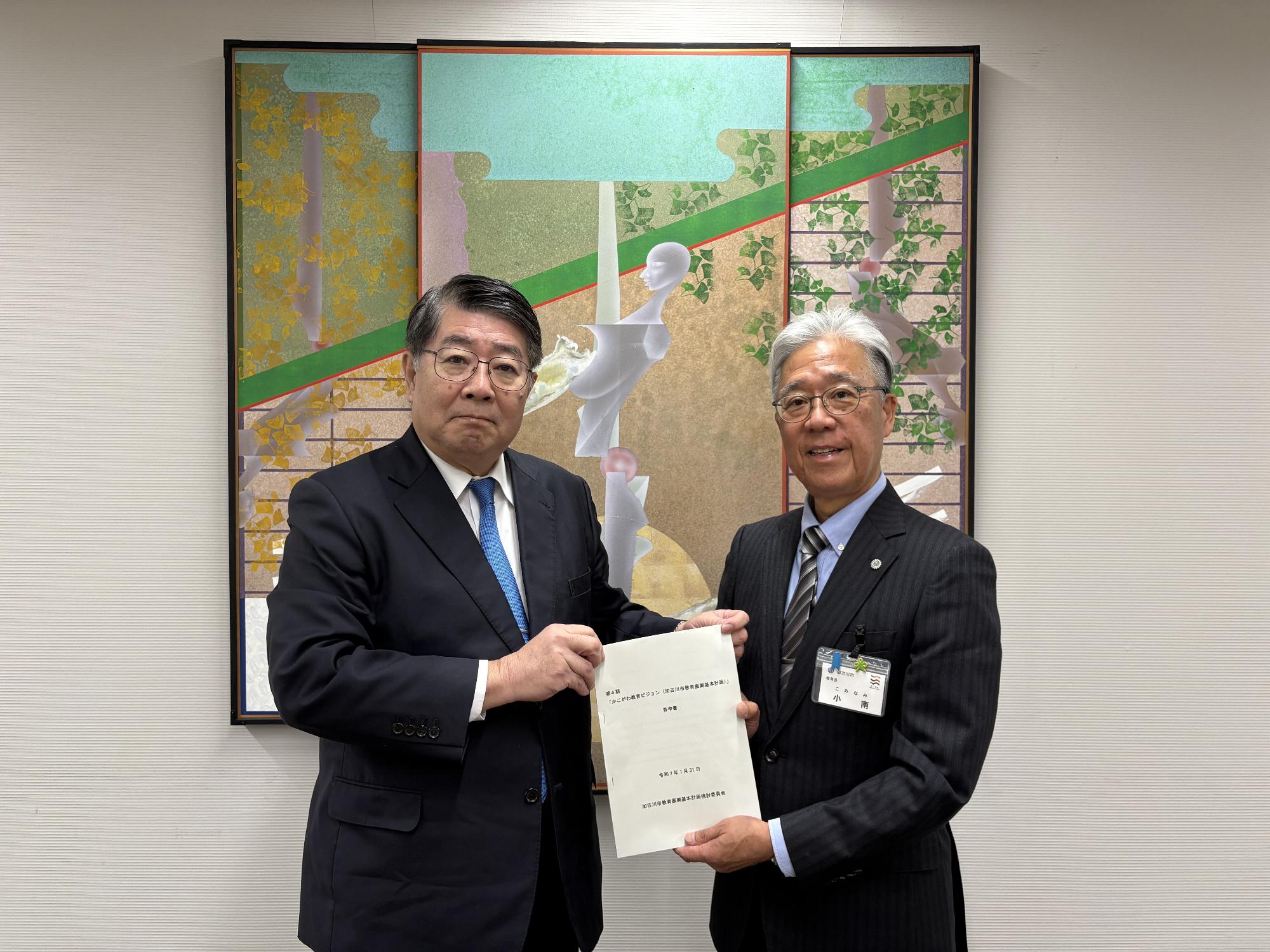 検討委員会委員長より教育長へ答申書を手渡している写真