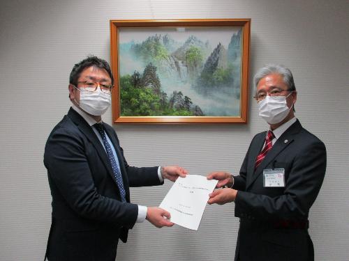 検討委員会委員長より教育長へ答申書を手渡している写真
