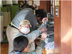 工具を使って作業をしている3人の男性の写真