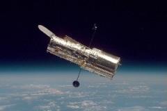 宇宙空間に浮かぶ筒形の望遠鏡の写真