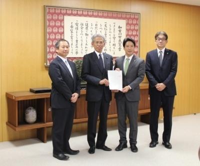 議長が議会事務事業評価に関する決議を市長に提出する様子の写真