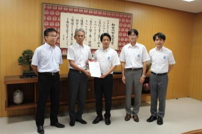議長が議会事務事業評価に関する決議を市長に提出する様子の写真