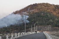 山から煙が上がっている山林火災の写真