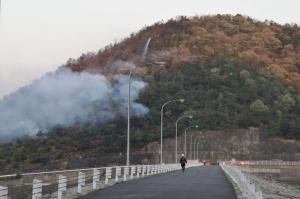 林野火災を消化するため消防団員が山頂から放水をしている写真