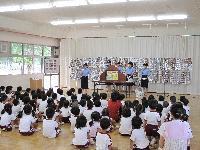 園児たちに防火について説明する女性署員の写真