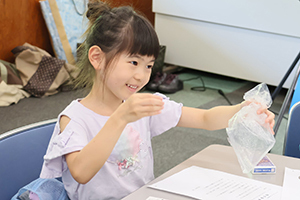 コインを使ったマジックを練習する女の子