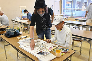 絵を描く男性と指導する先生