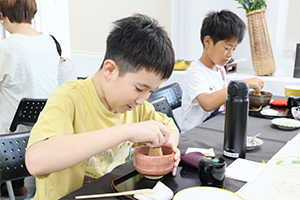 茶筅でお茶を立てる男の子
