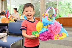 飾り付けた帽子を手に笑顔の男の子
