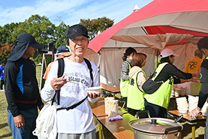 豚汁を手に笑顔の男性