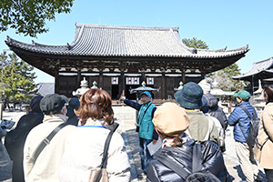 屋根瓦の説明をするガイドと参加者