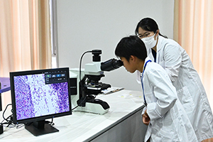 光学顕微鏡で菌を観察する男の子