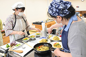 パスタとサラダの盛り付けをする参加者