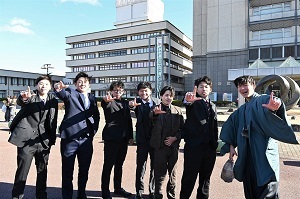 市役所前広場でお互いを祝う男性グループ