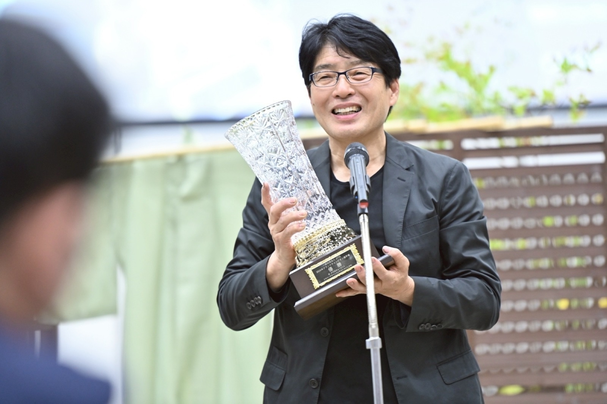 JFTD花キューピット　フラワーデザインコンテスト　グランドチャンピオン選手権で優勝し、優勝カップを手にする日坂さん
