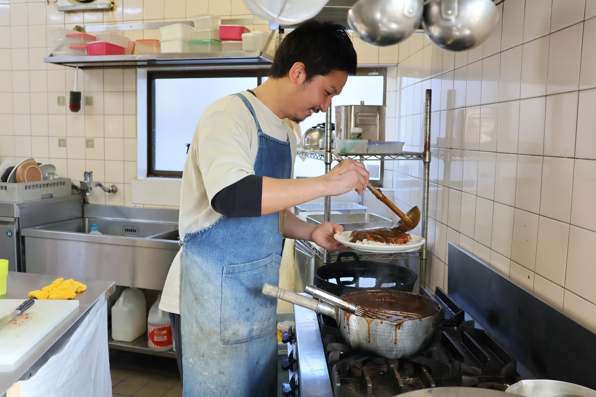 ソースをかけてかつめしを仕上げる一角さん