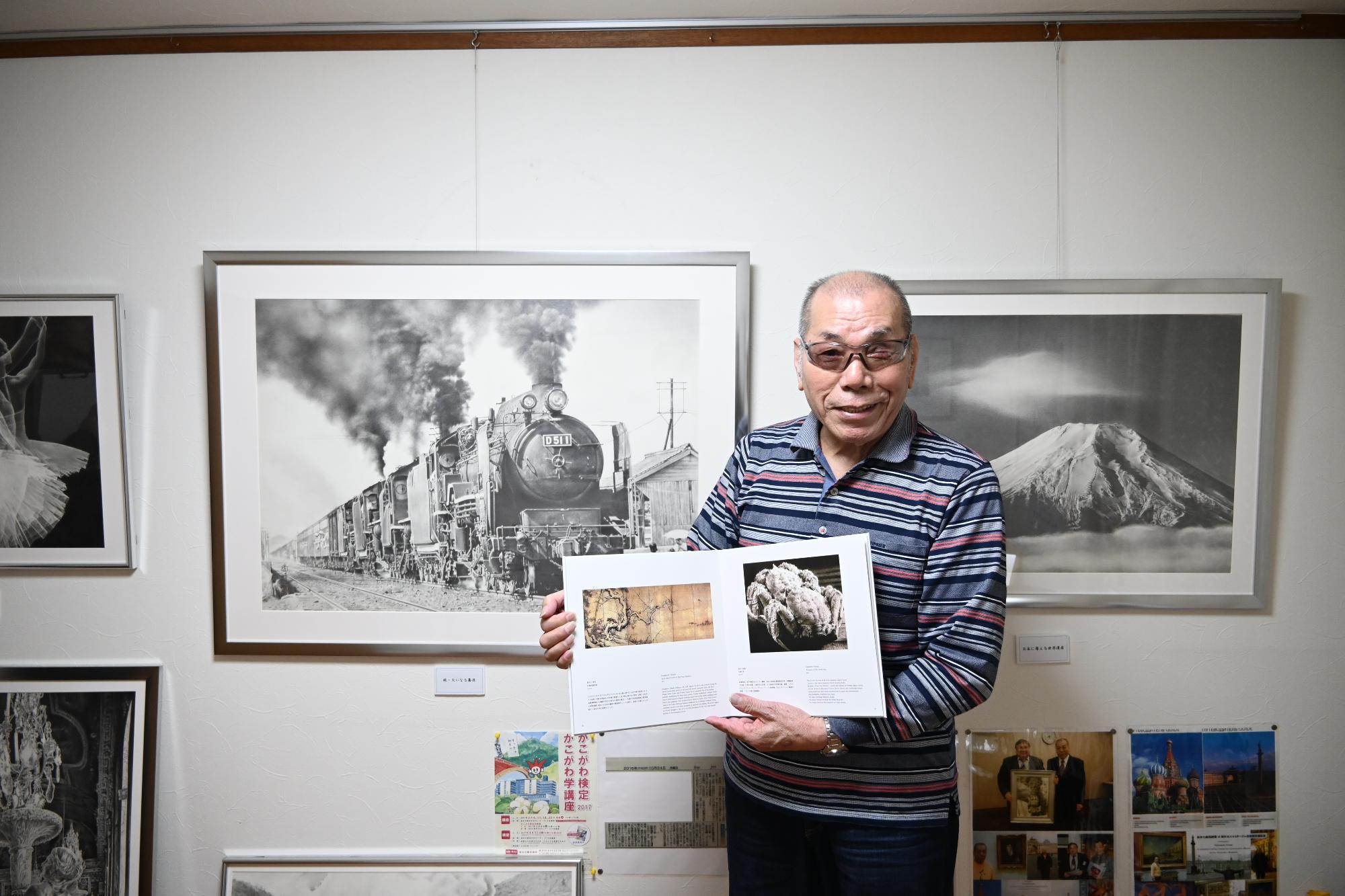 作品が掲載された国際美術書を持つ坂本さん