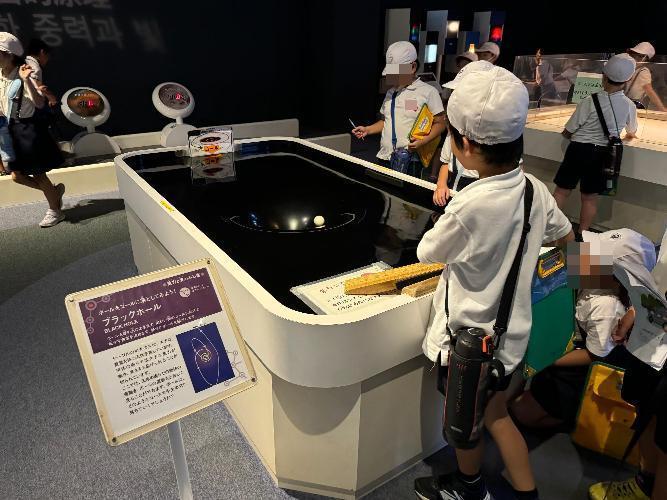 科学館にてブラックホールの仕組みを体験する写真