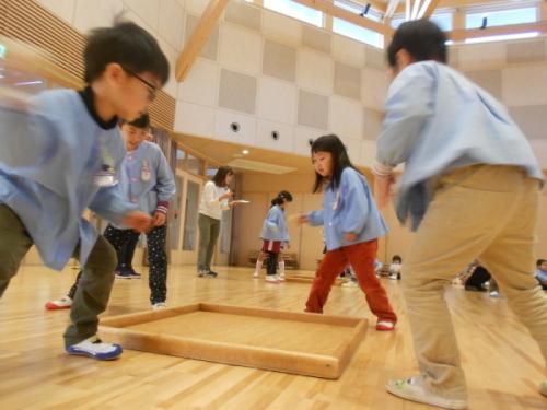 コマ回し大会でコマを回そうとしている園児たちの写真