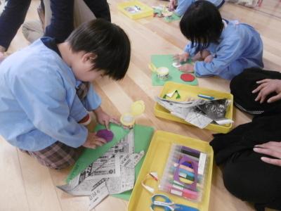 こどもの日のつどいでかぶる兜を親子で作っている写真