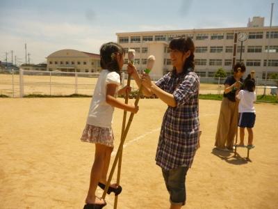親子ふれあい参観日で竹馬に乗って遊ぶ親子の写真