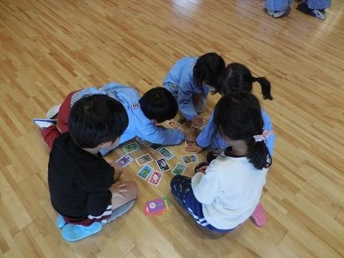 輪になってかるた取りをしている園児たちの写真