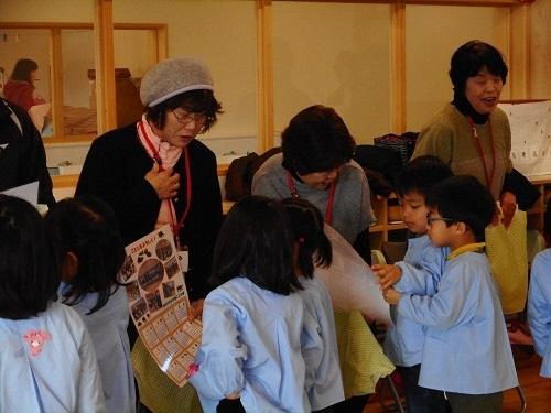老人会の方にカレンダーをプレゼントする園児たちの写真