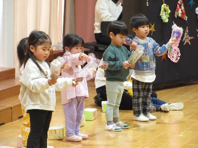 ペットボトルの手作り楽器を楽しむ2歳児
