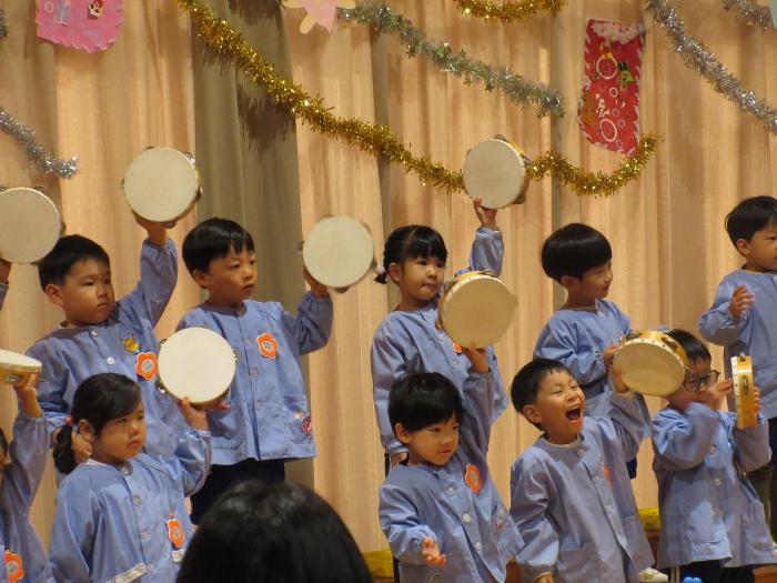 タンバリンを鳴らす3歳児