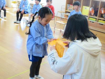 園長先生にご褒美をもらう3歳児