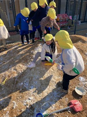 集めた雪でそり滑りを楽しむ4歳児