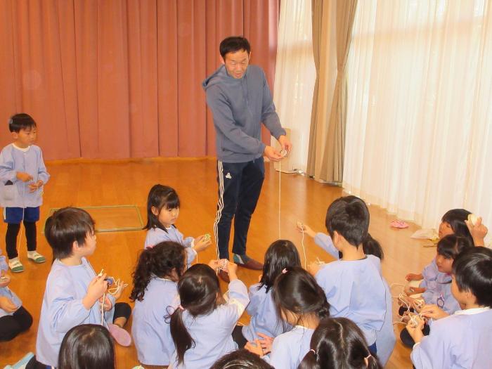 コマの紐の巻き方を聞く5歳児