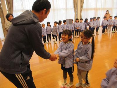 こま名人と握手をする4歳児