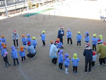 輪になってサンタさんにダンスを披露するこども