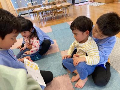 触れ合う0・1歳児と5歳児