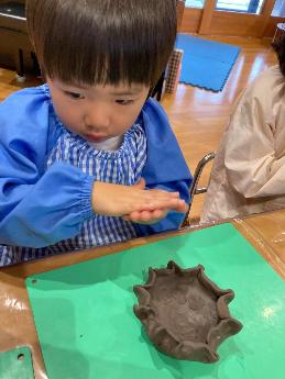 陶芸をする3歳児　皿の周りのデザインが凝っている