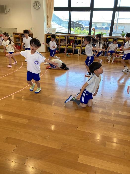 ツバメごっこをして空を飛ぶツバメを表現する5歳児