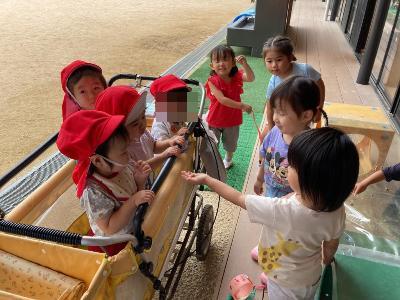 1歳児にカタツムリを見せる3歳児