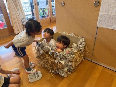自分たちでつくった巣に入ってツバメごっこをするこどもたち