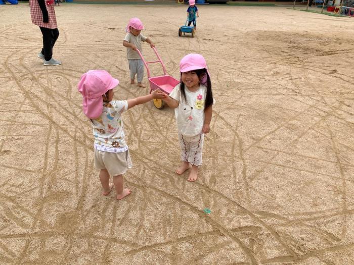 たくさんの線を作ったことを喜び友達とタッチする2歳児