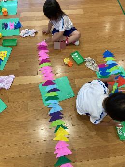 長い三角つなぎをつくる3歳児