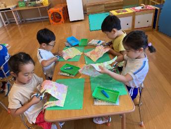 自分でも模様をつけた画用紙を使って製作する4歳児