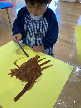 カブトムシの絵を描く3歳児