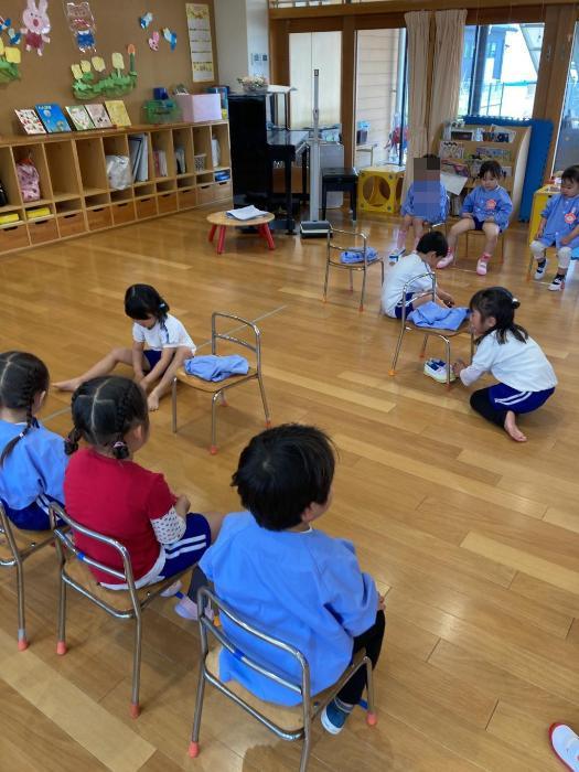 服の畳み方を教える4歳児