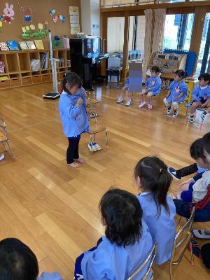 ボタンの留め方を見せる4歳児
