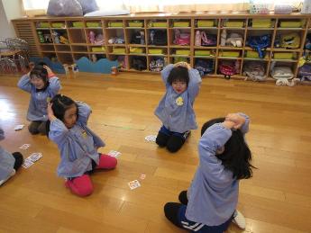 最後の1枚。お手付きしないように頭の上で手を組む4歳児。